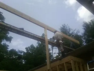 Carpenter setting a ridge beam over a new addition frame — Ice Dam Removal by Roofing Brothers in Klingerstown