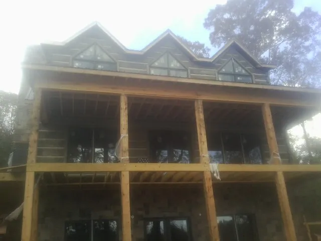 Dormers and porch framing on a large log home under construction — Roof Coating work by our crew in Klingerstown